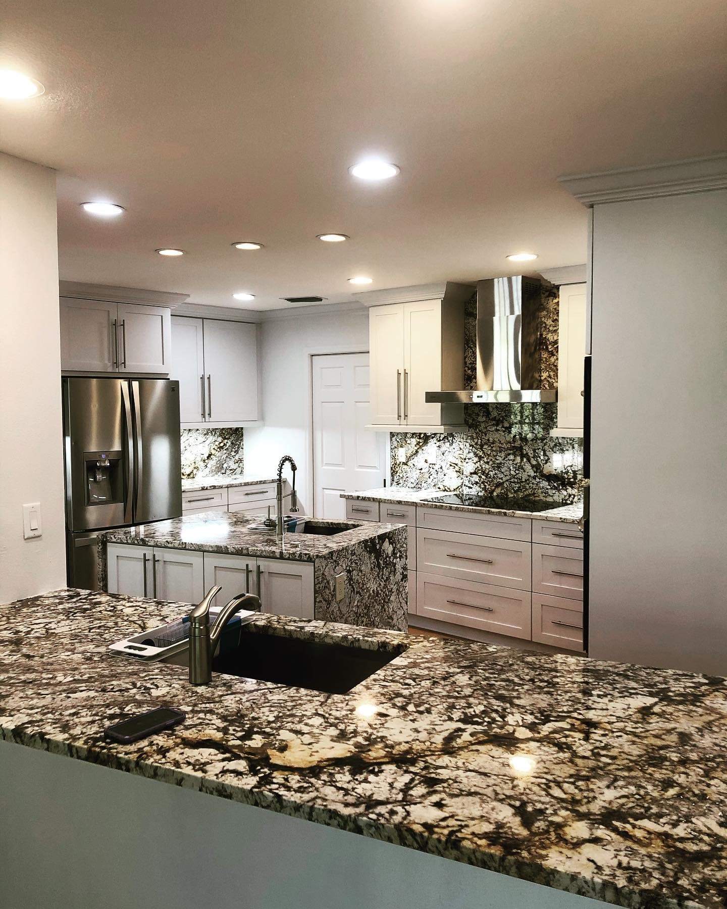 Finished granite kitchen with full-height stone backsplash by Stone Boyz